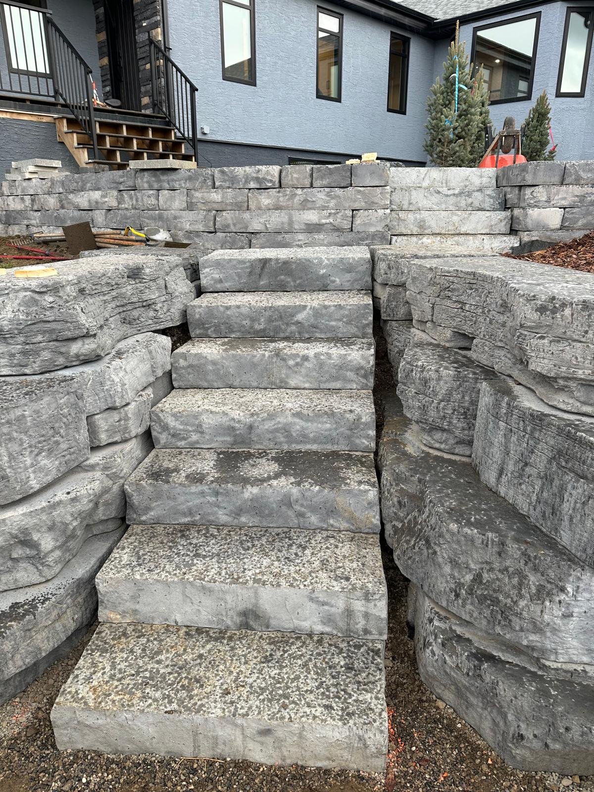 Large modular retaining-wall blocks being placed on a Calgary site by Sungreen.
