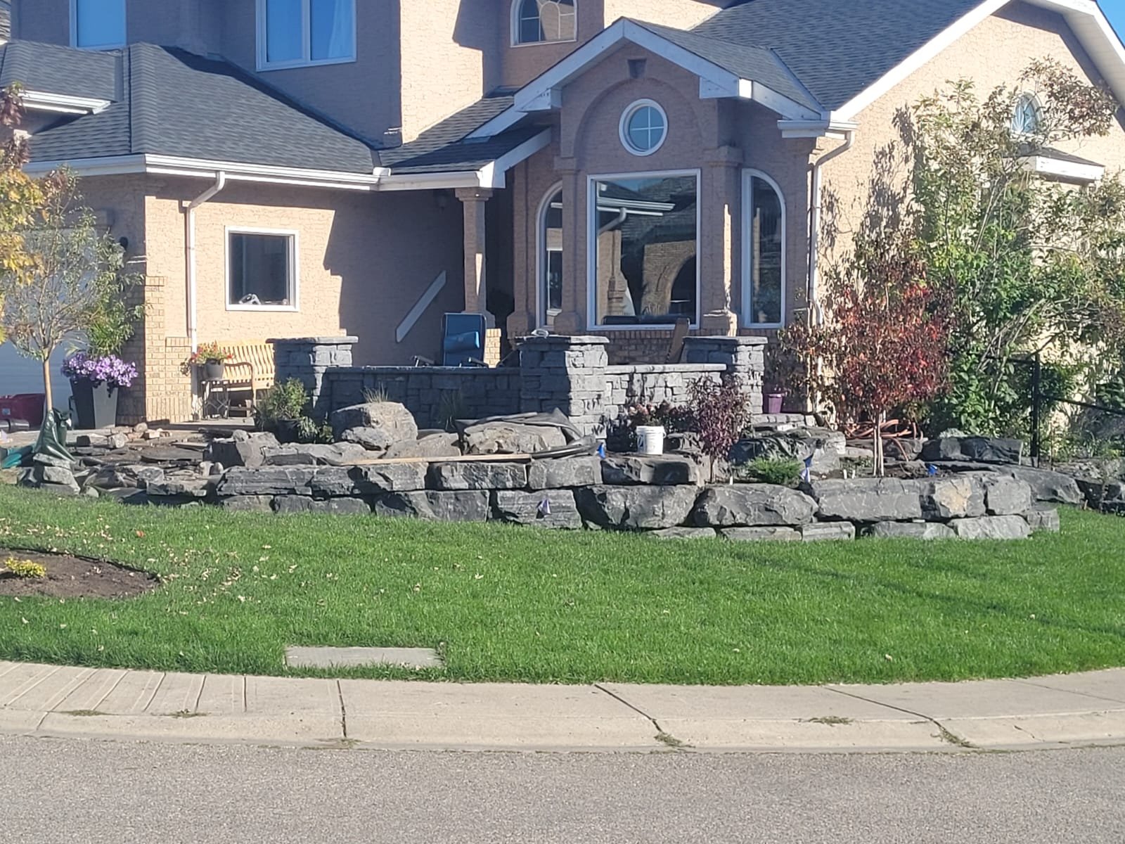 Boulder retaining wall and grade work at a Calgary-area home by Sungreen.