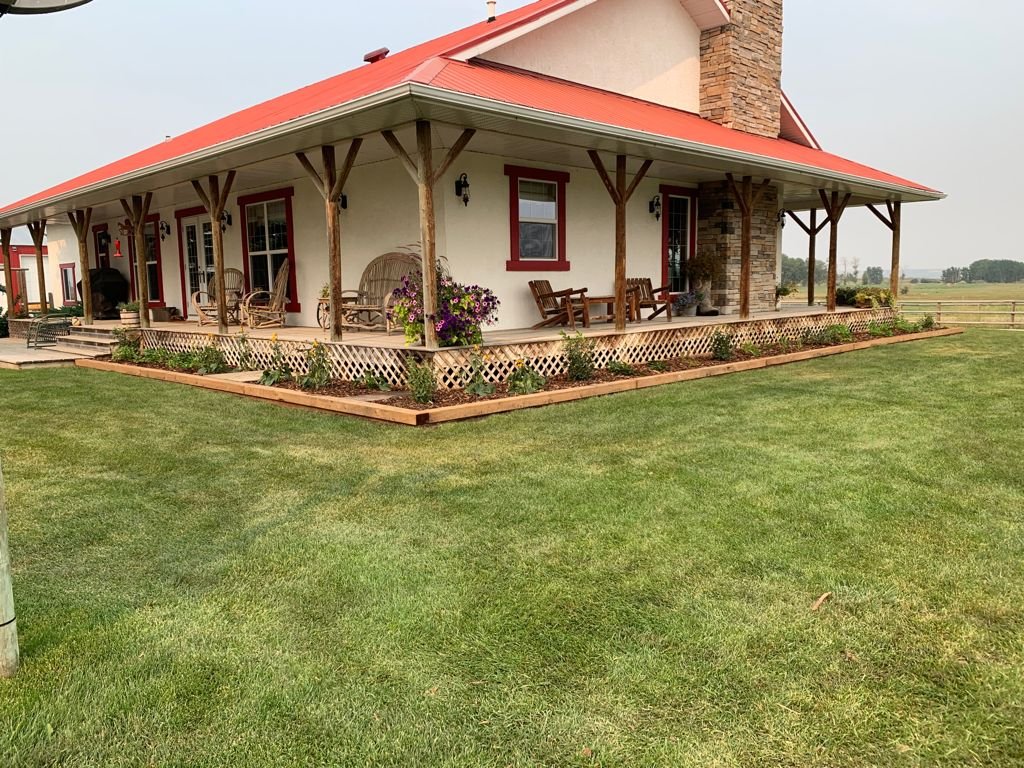 Covered pergola over a paver patio beside a Calgary lawn by Sungreen.