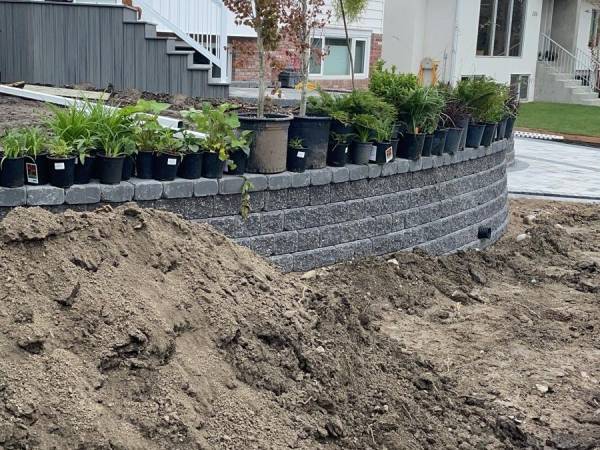 Mixed planting bed with shrubs and perennials along a stone path in Calgary by Sungreen.