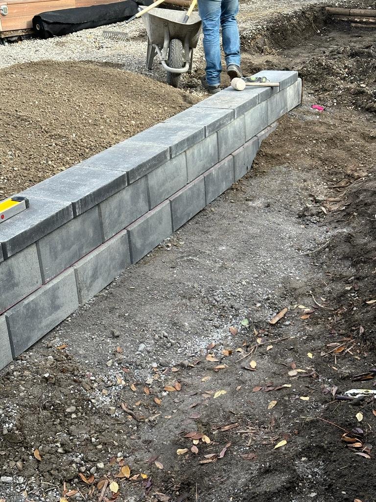 Modular-block retaining wall under construction in Calgary on a prepared base by Sungreen.