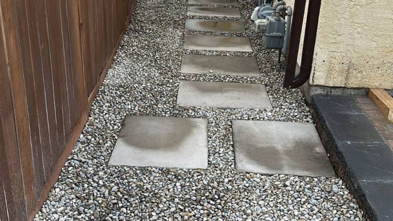 Square stepping-stone path on decorative gravel down a Calgary side yard by Sungreen.